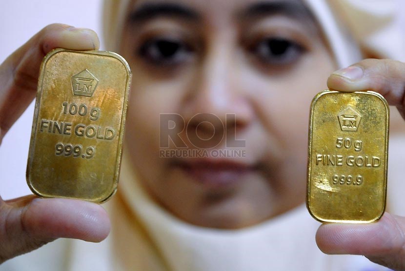 Petugas menunjukan emas batangan atau logam mulia produksi Aneka Tambang di Pegadaian, Jakarta, Senin (14/4).