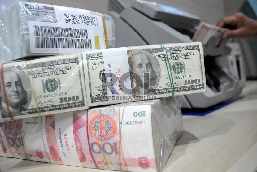 Petugas menunjukan mata uang Dolar AS di pooling cash Bank Mandiri, Jakarta, Jumat (22/8).(Prayogi/Republika)