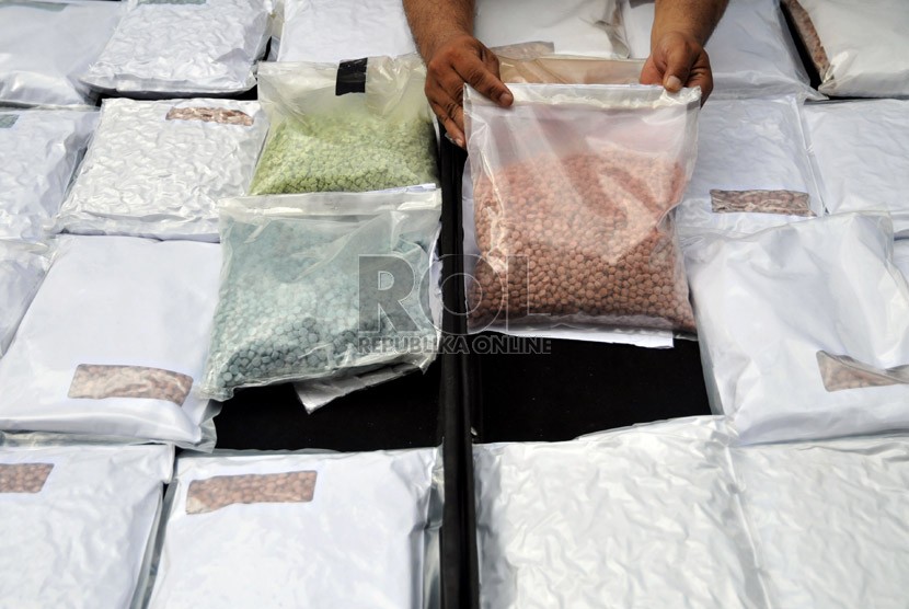  Petugas menunjukan ribuan barang bukti ekstasi yang berhasil disita di halaman Gedung Direktorat Tindak Pidana Narkoba Bareskrim Polri, Cawang, Jakarta Timur, Jumat (15/3). (Republika/Prayogi)