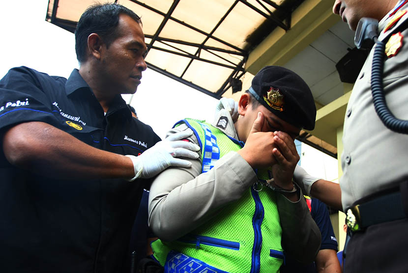 Petugas menunjukan seorang polisi gadungan berpangkat Brigadir yang baru saja diamankan di Mapolsek Serpong, Serpong, Tangerang Selatan, Banten, Rabu (10/2).  (Antara/Muhammad Iqbal)