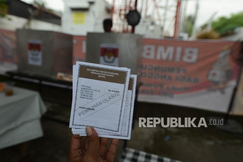 Petugas menunjukan suara saat pemungutan suara ulang (PSU) putaran kedua Pilkada DKI Jakarta di TPS 01 Gambir, Jakarta, Sabtu (22/4). 