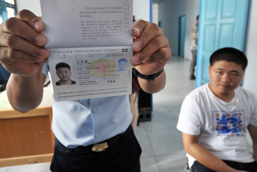 Petugas menunjukkan aspor milik salah seorang warga negara asing (WNA) asal Tiongkok yang diperiksa di ruang karantina Kantor Imigrasi Kelas I Jambi, Senin (3/4). 