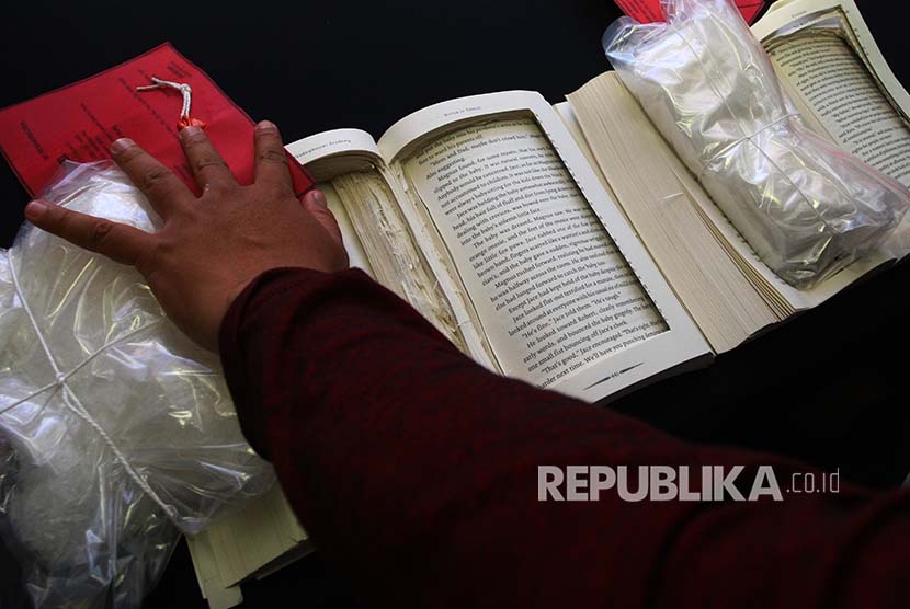 Petugas menunjukkan barang bukti 1,1 kg sabu yang diselundupkan dalam buku saat rilis di Kantor Bea dan Cukai Bandara Soekarno Hatta, Tangerang, Banten, Selasa (21/11). Kantor Bea Cukai dan Polres Bandara Soekarno Hatta berhasil menggagalkan penyelundupan 1,1 kg dari Malaysia ke Jakarta yang disembunyikan dalam buku.