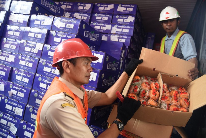 Petugas menunjukkan buah jeruk impor yang berada dalam Kontainer di Terminal Peti Kemas Surabaya, Jawa Timur, Jumat (4/3).