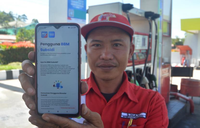 Petugas menunjukkan cara mendaftar di laman Pertamina sebelum membeli BBM bersubsidi di SPBU Kota Padangpanjang, Sumatra Barat, Jumat (1/7/2022). 