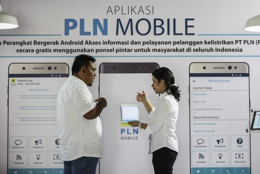 Petugas menunjukkan cara penggunaan aplikasi PLN Mobile kepada pengunjung saat peluncuran Aplikasi PLN Mobile di kantor PLN Pusat, Jakarta, Senin (31/10).