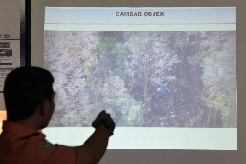 Petugas menunjukkan foto udara lokasi kecelakaan pesawat Trigana Air di Kantor Basarnas, Jakarta, Selasa (18/8). 