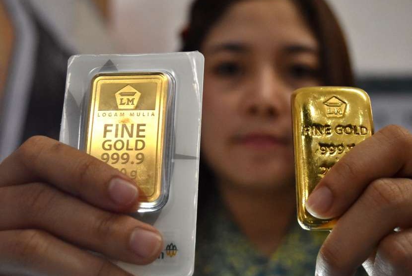 Petugas menunjukkan imitasi emas logam mulia produk PT Aneka Tambang (Antam). ilustrasi
