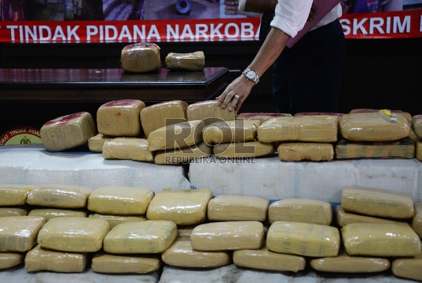  Petugas menunjukkan narkotika jenis ganja dan kurir saat rilis di Direktorat Tindak Pidana Narkoba (Dittipid Narkoba) Bareskrim Polri, Cawang, Jakarta, Senin (28/12). (Republika/Yasin Habibi)