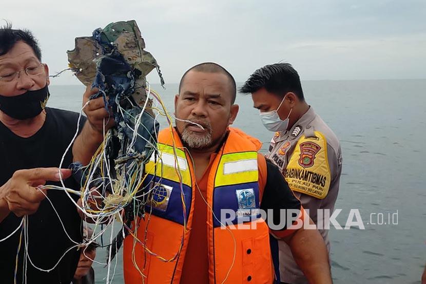 Petugas menunjukkan serpihan yang diduga berasal dari Pesawat SJY 182 di Kabupaten Kepulauan Seribu, DKI Jakarta, Sabtu (9/1)