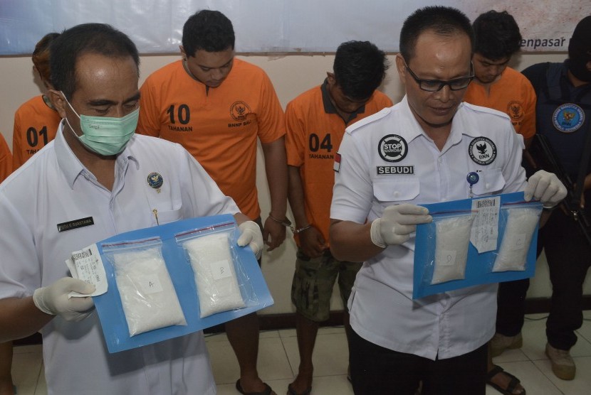 Petugas menunjukkan tersangka dan barang bukti kasus narkoba jenis Sabu saat rilis pengungkapan kasus narkoba jaringan Medan-Denpasar di Kantor Badan Narkotika Nasional (BNN) Provinsi Bali, Denpasar, Rabu (13/3/2019).