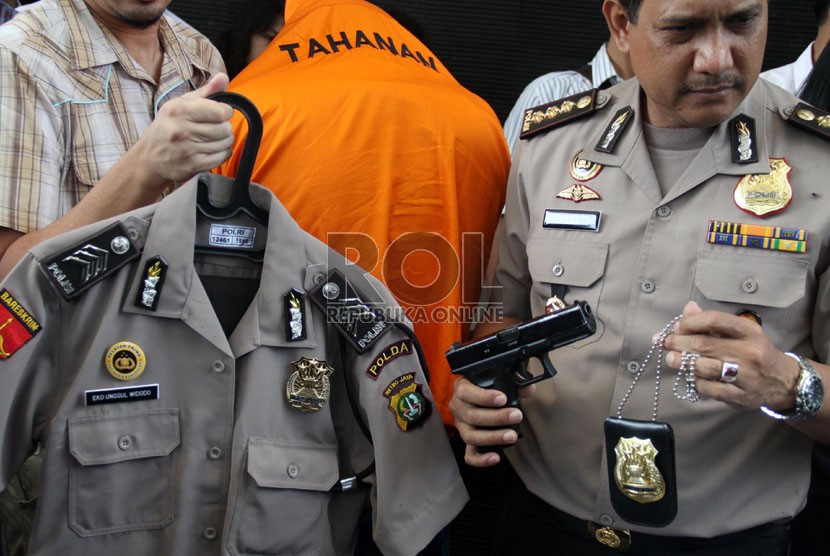   Petugas menunjukkan tersangka polisi gadungan beserta seragamnya, ilustrasi. Jajaran Polres Metro Bekasi Kota menangkap seorang polisi gadungan pria berinisial RZM (23 tahun) yang melakukan penusukan ibu dan anak di Jalan Cipete Raya, Mustikajaya, Kota Bekasi.