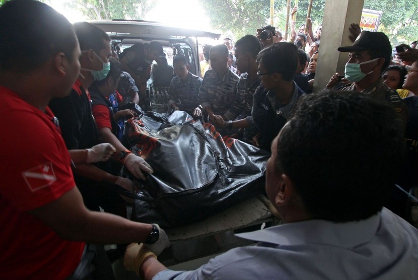 Petugas menurunkan kantong berisi jenazah korban pesawat Hercules C-130 saat tiba di Rumah Sakit Umum Pusat Adam Malik Medan, Sumatera Utara, Selasa (30/6).