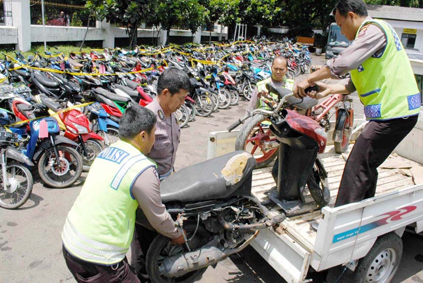 Petugas menurunkan motor bodong di Mapolrestabes Bandung, Jl Merdeka, Senin (2/2). (Edi Yusuf/Republika)