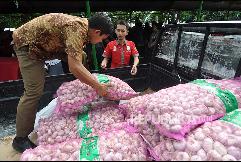 Petugas menurunkan ratusan kilogram bawang putih milik Bulog Sulawesi Tengah dari mobil pengangkut untuk dipasarkan pada pasar murah yang digelar di Palu, Sulawesi Tengah, Selasa (13/6). Menjelang perayaan Idul Fitri Bulog Sulawesi Tengah mendatangkan sekitar 20 ton bawang putih untuk selanjutnya dijual kepada masyarakat dengan harga lebih murah dibanding dipasaran guna menekan lonjakan harga bawang putih dipasaran yang menembus Rp 50.000 hingga Rp 60.000 perkilogram. 