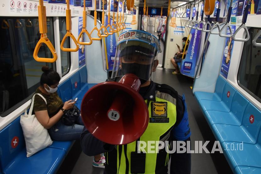Petugas menyampaikan imbauan protokol kesehatan kepada penumpang MRT di Stasiun Bunderan HI, Jakarta.