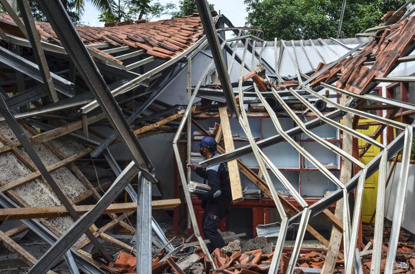 Petugas menyelamatkan barang-barang sekolah pasca ambruknya atap ruang kelas