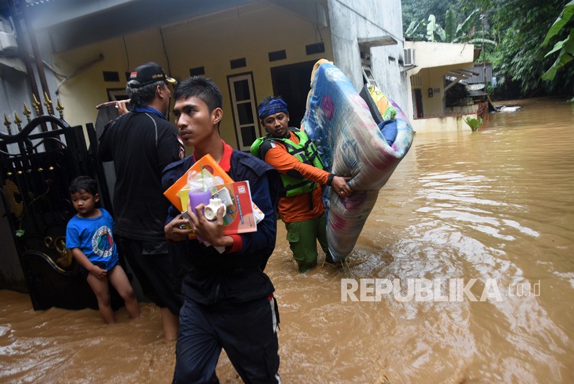 Petugas menyelamatkan barang-barang yang masih berharga saat banjir melanda permukiman bantaran Sungai Ciliwung di Jalan Gotong Royong, Kemirimuka, Beji, Depok, Jawa Barat, Senin (5/2).