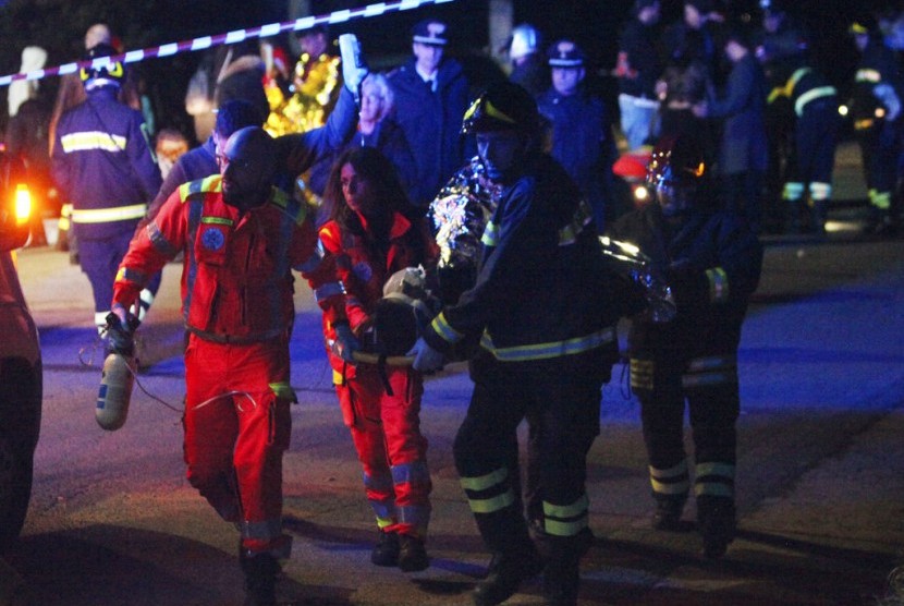 Petugas menyelamatkan korban runtuhnya jalan keluar klub malam Lanterna Azzurra di Kota Corinaldo, Ancona, Italia, Sabtu (8/12).