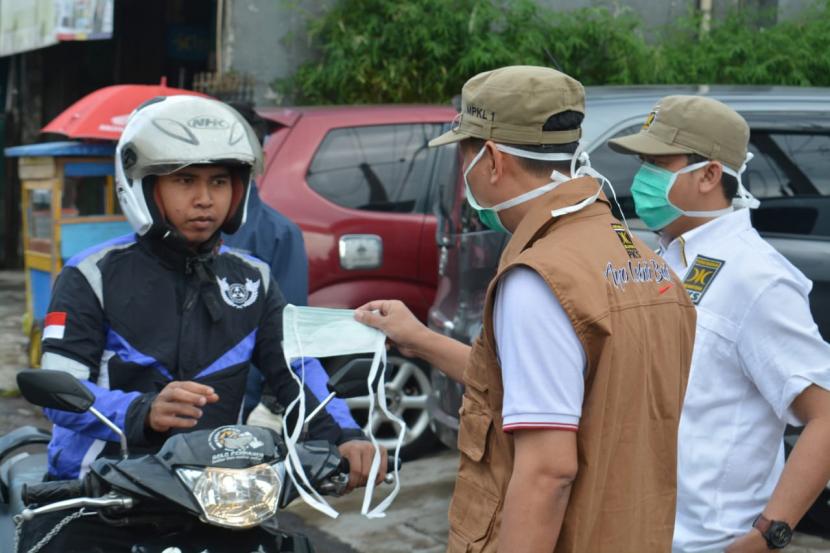 Petugas menyemprot disinfektan di masjid tempat transit warga di Kota/Kabupaten Sukabumi dan membagikam masker, Ahad (22/3). 