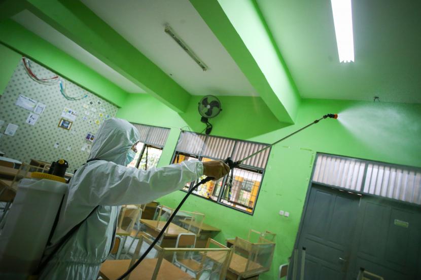 Petugas menyemprotkan cairan disinfektan di area sekolah SMAN 20, Jakarta, Jumat (14/1/2022). Sudin Pendidikan Wilayah I Jakarta Pusat menghentikan sementara Pembelajaran Tatap Muka (PTM) di SMAN 20, Sawah Besar setelah seorang siswa terkonfirmasi positif COVID-19 sejak Selasa (11/1/2022) hingga Minggu (16/1/2022).