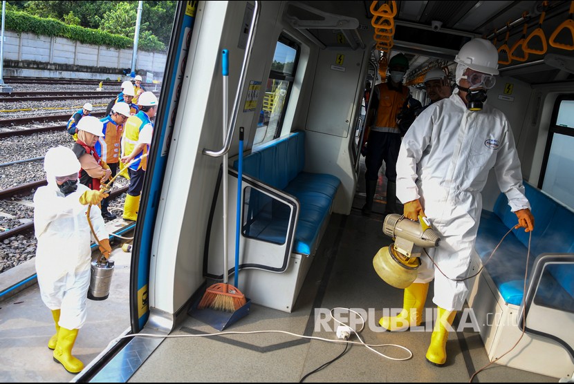 Petugas menyemprotkan cairan disinfektan didalam gerbong kereta di Depo Light Rail Transit (LRT) Sumatera Selatan, Palembang, Selasa (10/3/2020).( Antara/Nova Wahyudi )
