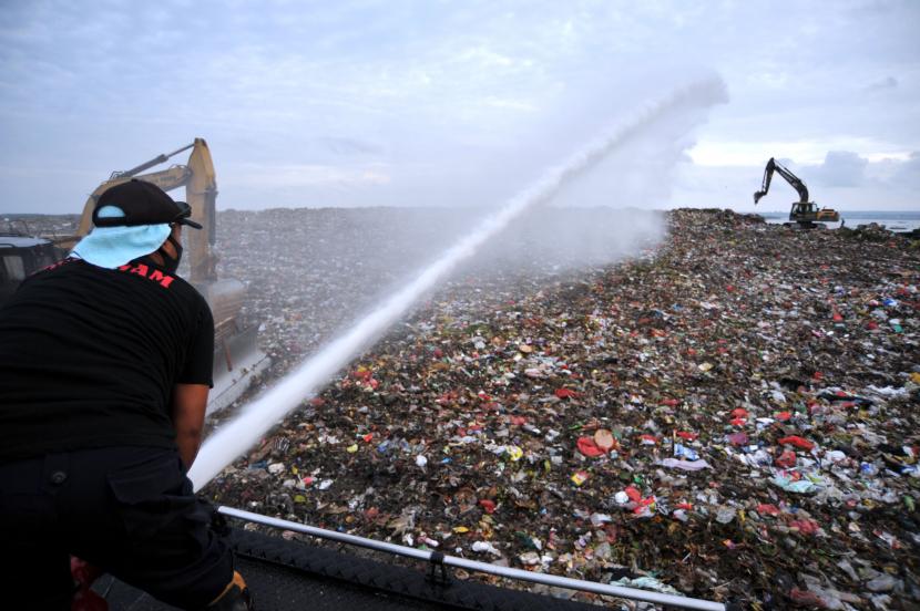 Petugas menyemprotkan cairan Eco-Enzyme saat peringatan Hari Peduli Sampah Nasional di Tempat Pembuangan Akhir (TPA) Suwung, Denpasar, Bali, Minggu (21/2/2021). 