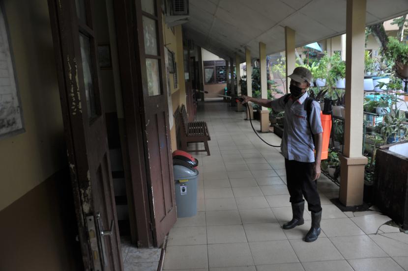 Petugas menyemprotkan disinfektan di selasar SMP Negeri 1 Palembang, Senin (18/1/2021). Meskipun pelaksanaan sekolah tatap muka belum ditetapkan, sejumlah sekolah di Kota Palembang mulai melakukan berbagai persiapan diantaranya penyemprotan disinfektan rutin dan pengadaan sarana protokol kesehatan.