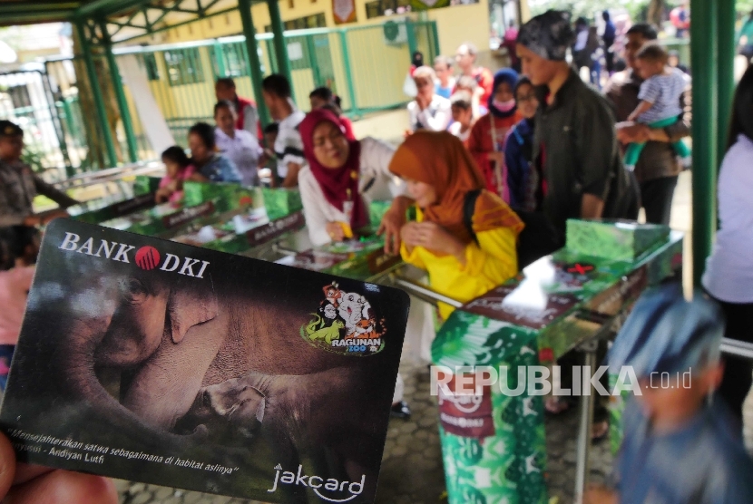 Pengunjung menggunakan Kartu Jakcard Bank DKI sebagai tiket elektronik saat memasuki gerbang tiketing Taman Margasatwa Ragunan (TMR) di Jakarta, Ahad (8/5). (Republika/ Yogi Ardhi)