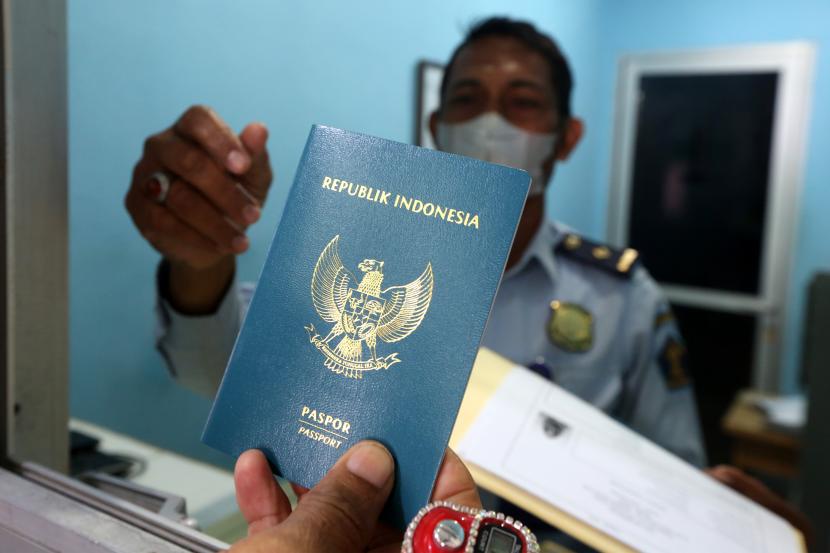 Petugas menyerahkan paspor kepada warga. 