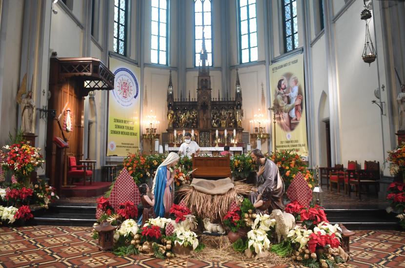 Petugas menyiapkan altar menjelang ibadah misa malam Natal di Gereja Katedral, Jakarta, jumat (24/12/2021).