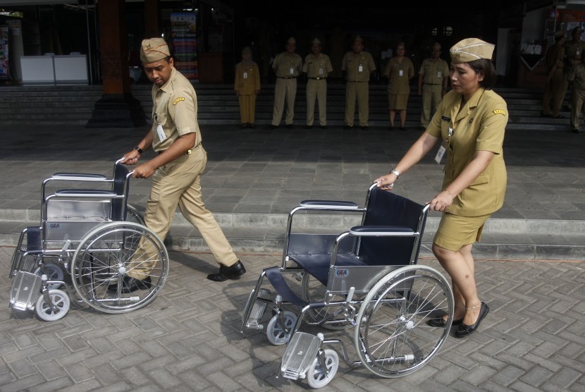 Petugas menyiapkan kursi roda bantuan untuk pensiunan Aparatur Sipil Negara (ASN) saat acara peringatan Hari Otonomi Daerah (Otda) di Balai Kota Solo, Jawa Tengah, Kamis (25/04/2019).