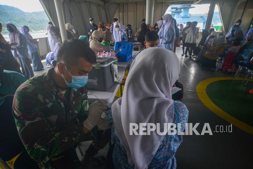 Petugas menyuntikan vaksin kepada seorang pelajar di atas KRI Bontang-907, di Pelabuhan Teluk Bayur, Padang, Sumatera Barat, Kamis (14/10/2021). Kedatangan KRI Bontang-907 ke Padang dalam rangka serbuan vaksin maritim dilaksanakan TNI-AL untuk membantu pemerintah mempercepat penyelesaian program vaksinasi COVID-19. 
