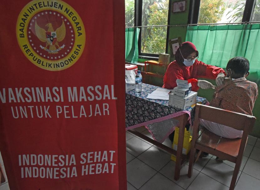 Petugas menyuntikkan vaksin COVID-19 kepada anak saat Vaksinasi Massal Untuk Pelajar di SD Negeri Bujanggadung, Cilegon, Banten, Rabu (19/1/2022). Pemprov setempat bekerjasama dengan BIN dan TNI-Polri menggelar vaksinasi massal untuk anak usia 6-11 tahun di 8 wilayah Kabupaten/Kota.