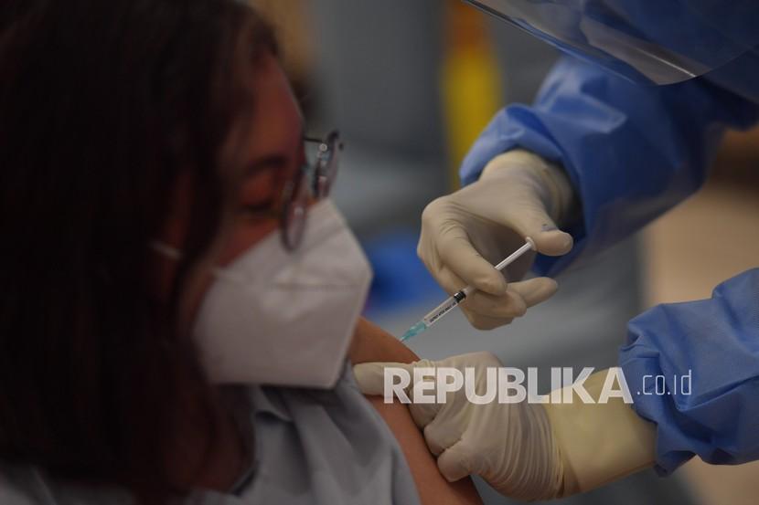 Petugas menyuntikkan vaksin COVID-19 produksi Sinovac saat pelaksanaan vaksinasi massal di Surabaya, Jawa Timur, Ahad (31/1/2021). Vaksinasi massal tersebut diikuti kurang lebih 5.000 tenaga kesehatan. 
