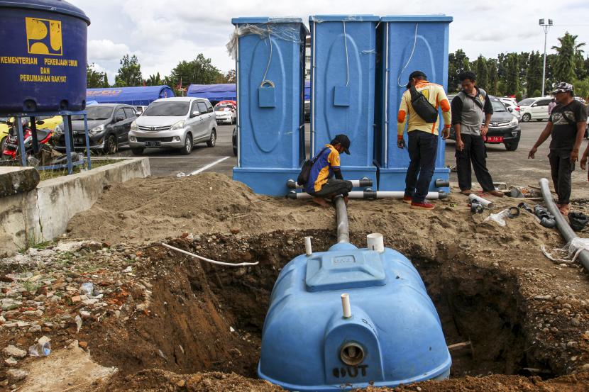 Petugas menyusun toilet portable di lokasi pengungsian korban bencana gempa bumi di kantor bupati Pasaman Barat, Selasa (1/3/2022). Kementerian Pekerjaan Umum dan Perumahan Rakyat (PUPR) menyediakan toilet portable untuk membantu warga yang mengungsi akibat gempa.