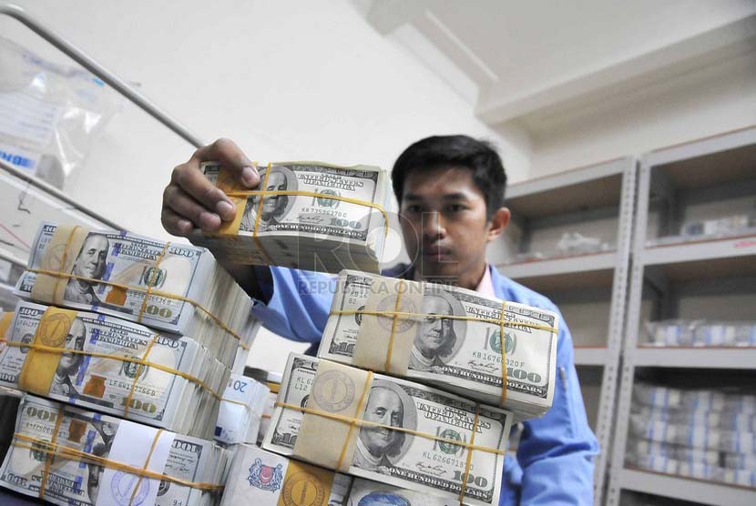 Petugas merapihkan mata uang dollar Amerika, di Cash Center Bank BRI, Jakarta, Selasa (1/7). 