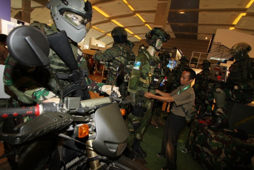 Petugas merapikan susunan pakaian anti peluru pada Indo Defence Expo 2014 di JIEXPO Kemayoran, Jakarta, Rabu (5/11). Pameran industri pertahanan berskala internasional itu digelar hingga 8 November.