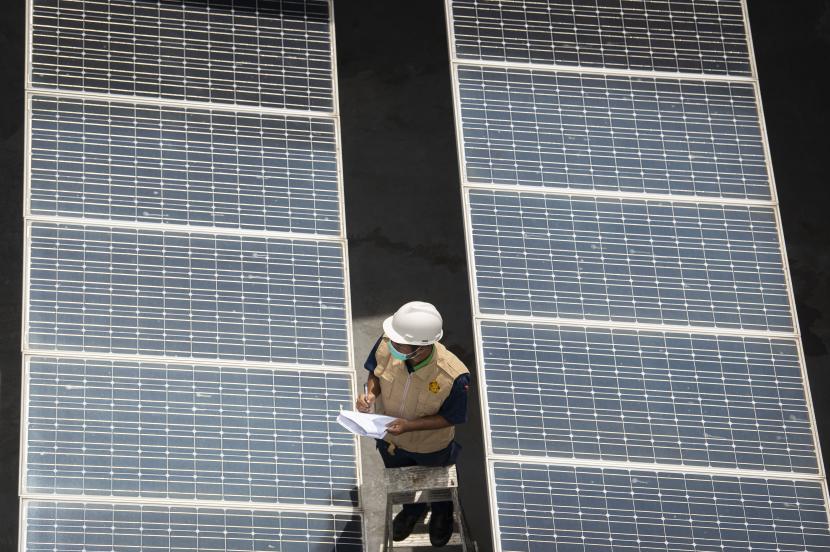 Petugas merawat panel surya yang terpasang di atap gedung Direktorat Jenderal (Dirjen) Ketenagalistrikan Kementerian Energi dan Sumber Daya Mineral (EDSM), Jakarta, Rabu (24/3/2021).