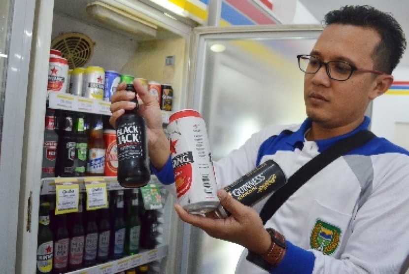 Petugas merazia minuman beralkohol yang dijual di sebuah minimarket di Kota Madiun, Jumat (30/1).