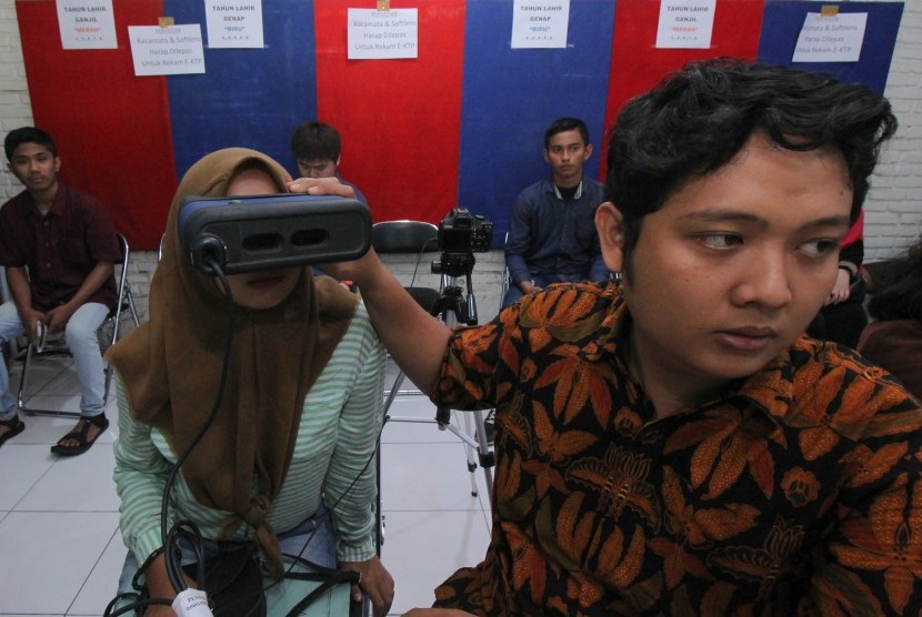 Petugas merekam (scan) mata warga yang mengajukan pembuatan Kartu Tanda Penduduk (KTP) elektronik di Dinas Kependudukan dan Pencatatan Sipil Surabaya, Jawa Timur, Kamis (5/7).