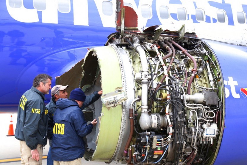 Petugas National Transportation Safety Board memeriksa kerusakan mesin pesawat Southwest Airlines. Pada Selasa (17/4), mesin jet pesawat ini meledak di ketinggian 31 ribu kaki.