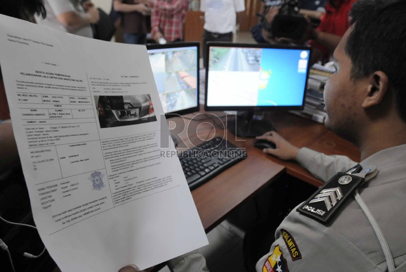   Petugas operator melakukan pemantauan lewat monitor CCTV saat uji coba pemberlakukan tilang elktronik di kantor National Traffic Management Centre (NTMC), Jakarta, Ahad (9/11).(Republika/Rakhmawaty La'lang )