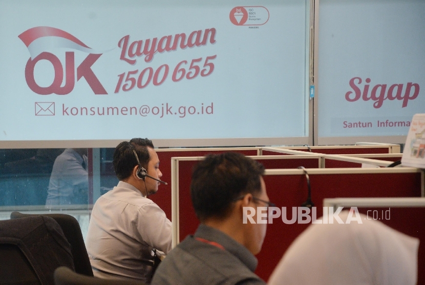 Petugas Otoritas Jasa Keuangan (OJK) beraktivitas di ruang layanan Konsumen Kantor OJK, Jakarta, Senin (23/10).