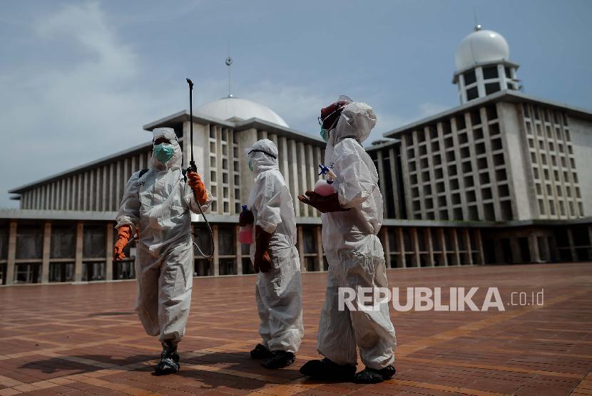 Petugas Palang Merah Indonesia (PMI) Jakarta Pusat menyemprotkan cairan disinfektan di area Masjid Istiqlal, Jakarta, Jumat (13/3).(Republika/Thoudy Badai)