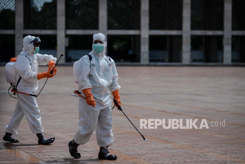  Petugas PMI Jakpus menyemprotkan cairan disinfektan di area Masjid Istiqlal.