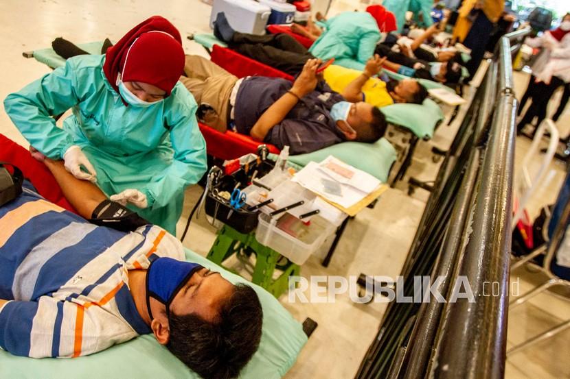 Petugas Palang Merah Indonesia (PMI) melakukan tranfusi darah pendonor saat kegiatan Gebyar Donor Darah di Karawang, Jawa Barat, Sabtu (12/6/2021). Kegiatan tersebut untuk memenuhi kuota kantong darah sekaligus memperingati Hari Donor Darah Sedunia.