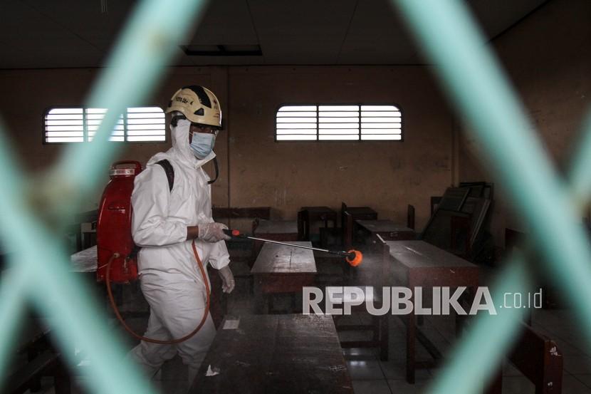 Petugas Palang Merah Indonesia (PMI) menyemprotkan disinfektan di salah satu sekolah di Depok, Jawa Barat, Senin (31/1/2022). Berdasarkan data Satgas COVID-19 Kota Depok, sebanyak 28 sekolah dari tingkat SD, SMP dan SMA di wilayah tersebut terdapat 197 kasus positif COVID-19 sehingga sekolah sementara ditutup untuk sterilisasi. 