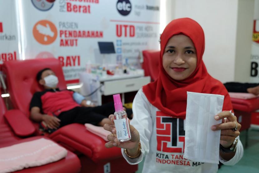 Pendonor Darah di PMI Tangerang Anjlok Hingga 70 Persen. Petugas Palang Merah Indonesia (PMI) menunjukkan hand sanitizer dan masker saat mengambil darah pendonor di kantor PMI.