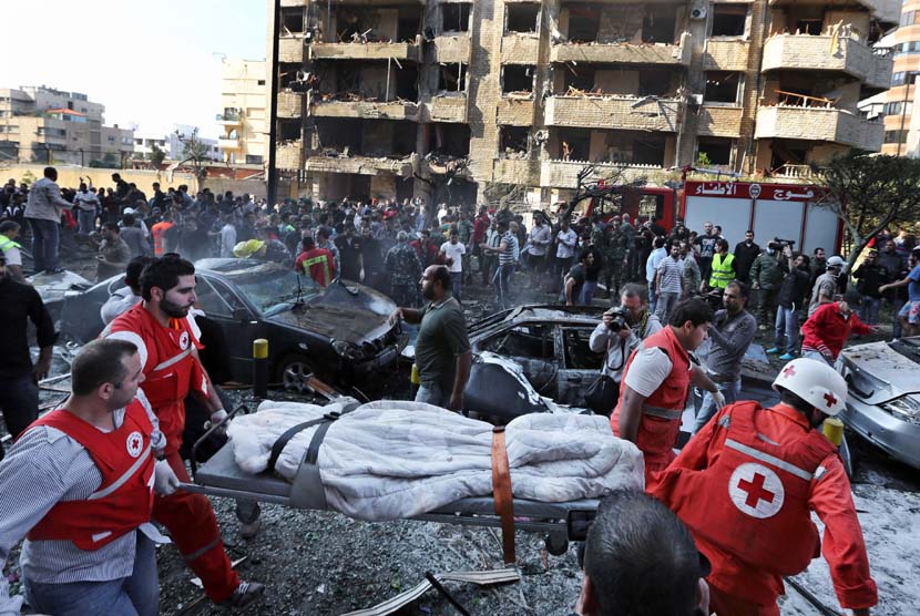  Petugas Palang Merah Lebanon mengevakuasi mayat di lokasi dua ledakan yang meledak dekat Kedutaan Besar Iran di Beirut, Lebanon, Selasa (19/11). (AP/Hussein Malla) 